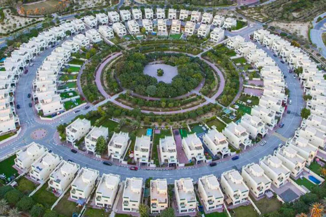 Lush green community park in Jumeirah Village Circle (JVC), Dubai, near Heritage Development properties.